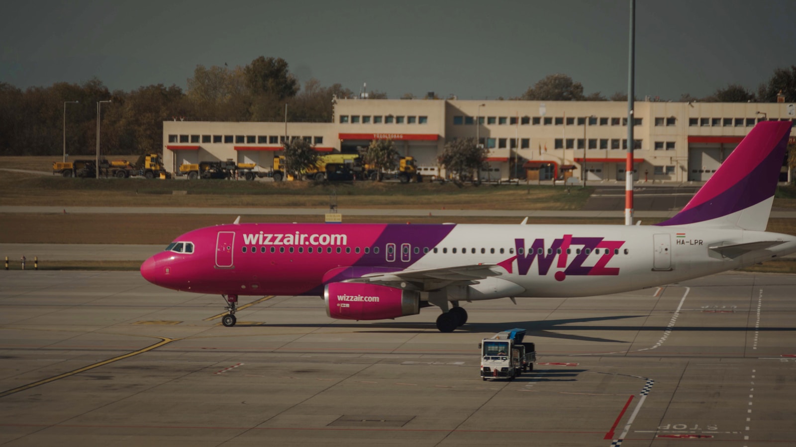 Ce inseamna Wizz Priority red and white passenger plane on airport during daytime